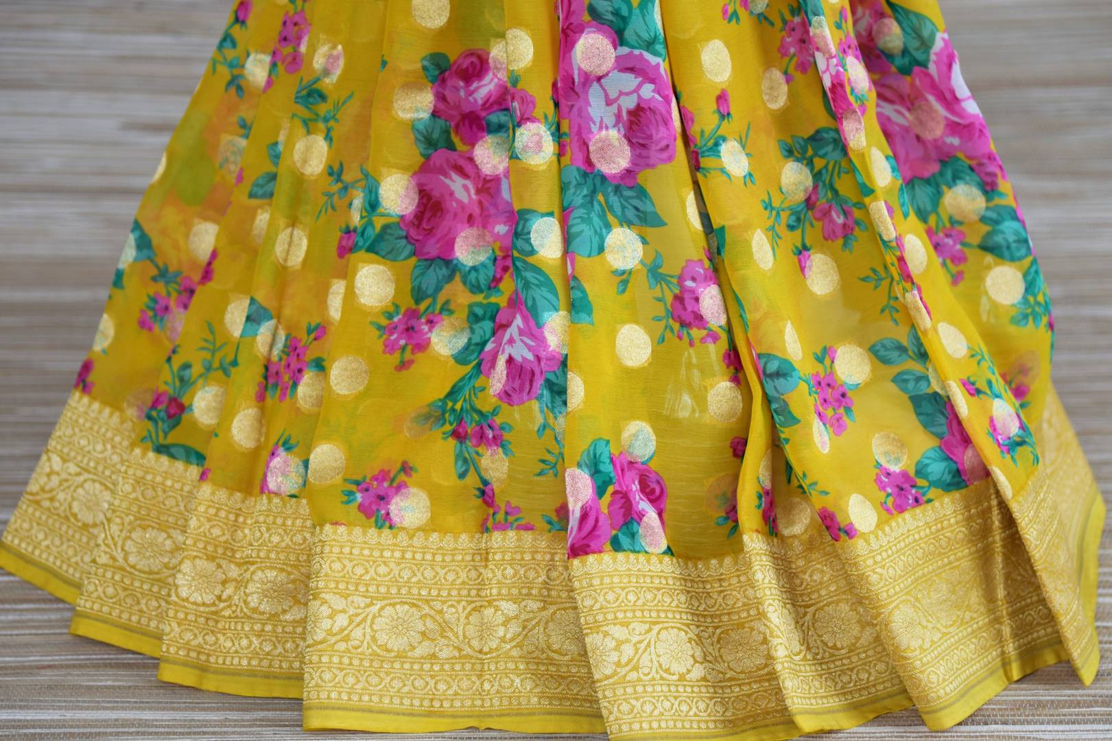 Buy bright yellow floral georgette Banarasi sari online in USA with zari border. Radiate traditional charm with beautiful Banarasi sarees from Pure Elegance Indian clothing store in USA. Choose from a variety of Banarasi silk sarees, Banarasi georgette sarees, Banarasi tussar saris for special occasions.-pleats