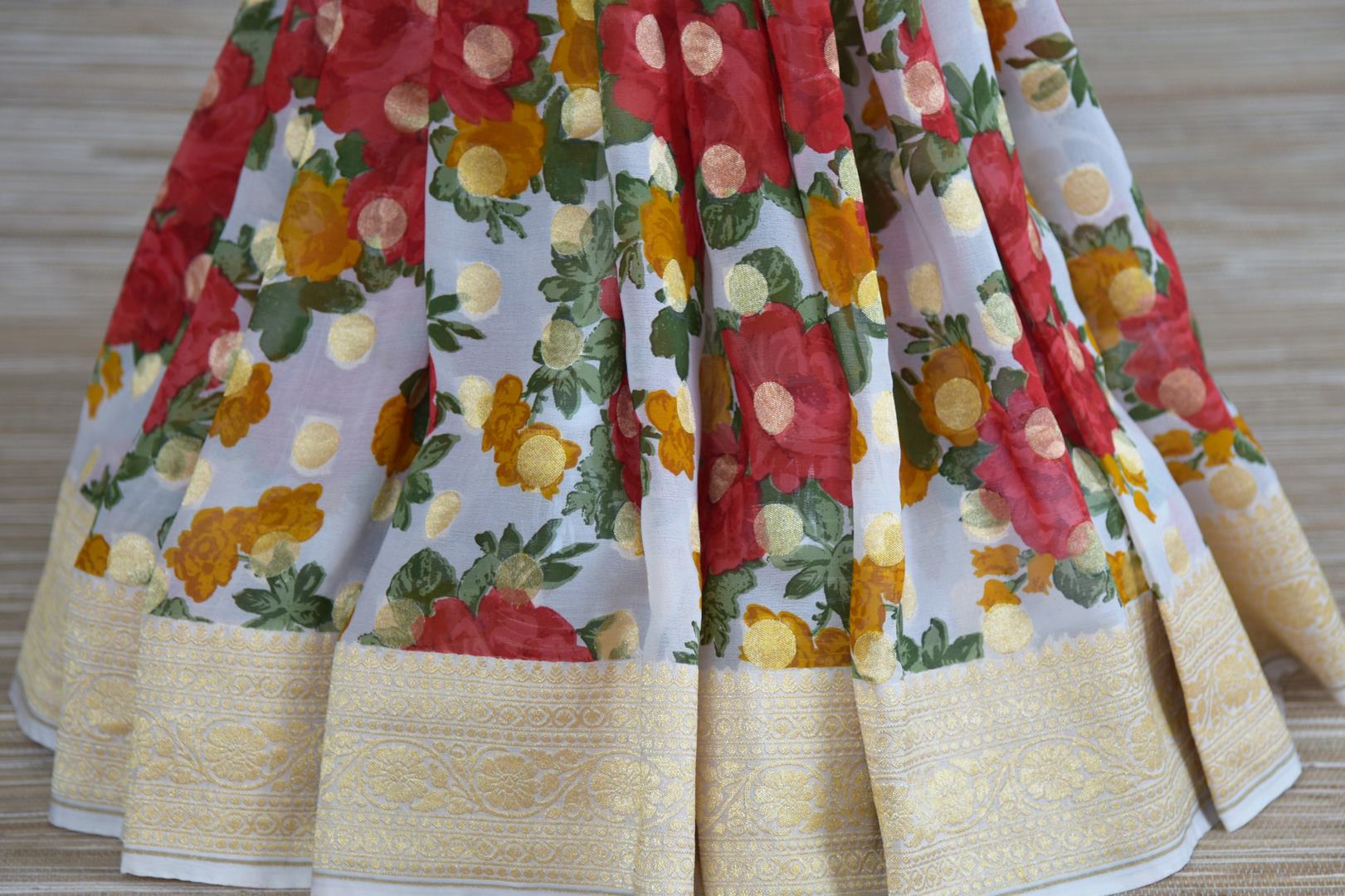 Buy powder blue red floral georgette Banarasi sari online in USA with zari border. Radiate traditional charm with beautiful Banarasi sarees from Pure Elegance Indian clothing store in USA. Choose from a variety of Banarasi silk sarees, Banarasi georgette sarees, Banarasi tussar saris for special occasions.-pleats