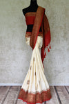 Buy off-white muga Banarasi sari online in USA with zari buta and red antique zari border and pallu. Be an epitome of elegance in exquisite Banarasi saris from Pure Elegance Indian clothing store in USA.-full view