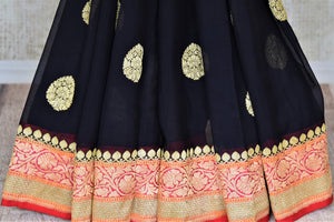 Buy captivating black floral zari buta georgette Banarasi saree online in USA. Go for an extraordinary traditional look with splendid handwoven sarees, embroidered sarees with blouses, Banarasi saris from Pure Elegance from Indian cloth store in USA.  Shop online or visit our store now.-pleats