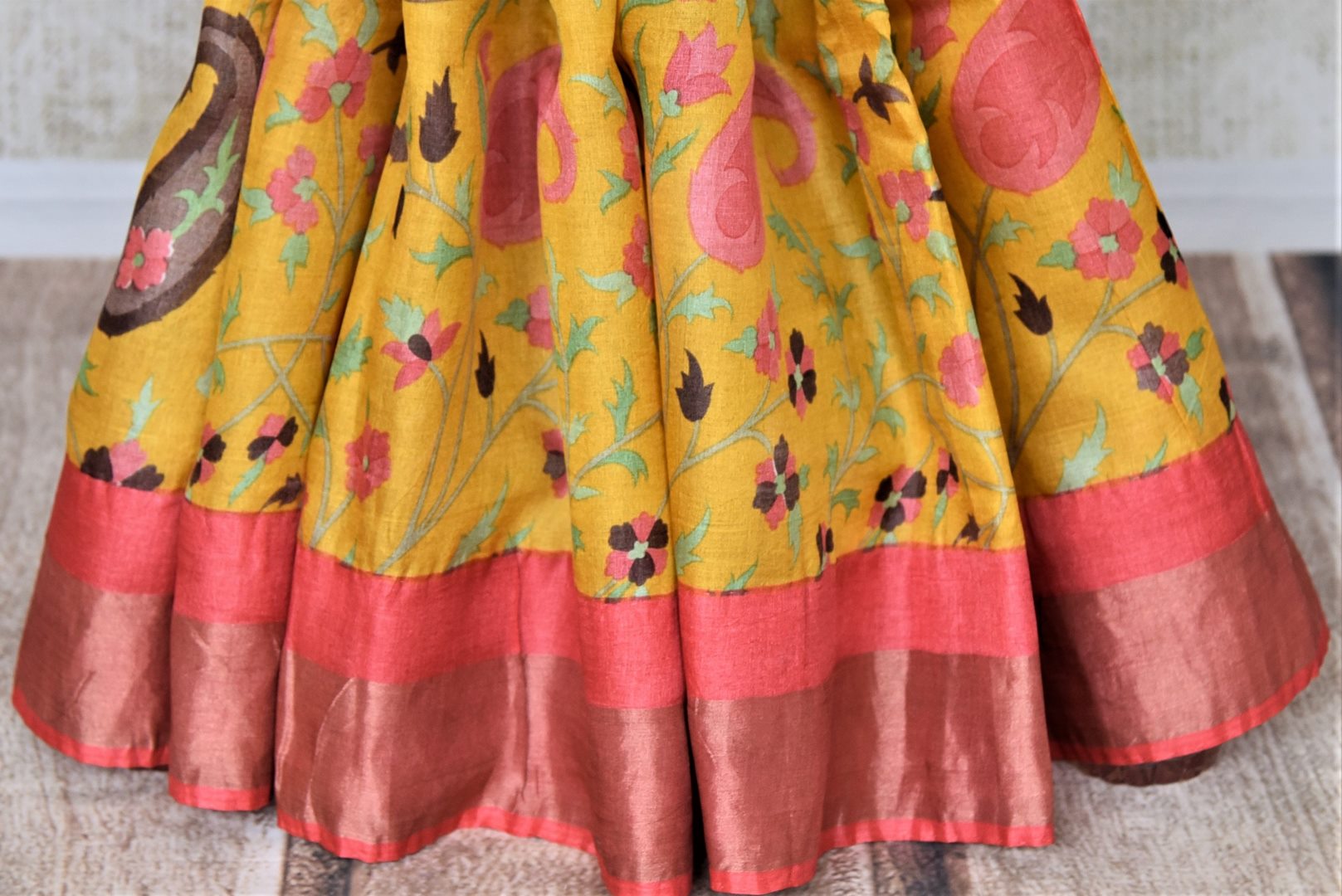 Shop charming yellow floral print tassar sari online in USA with pink zari border. Be the talk of the occasions in exquisite tassar sarees, handwoven silk saris from Pure Elegance Indian fashion store in USA. -pleats
