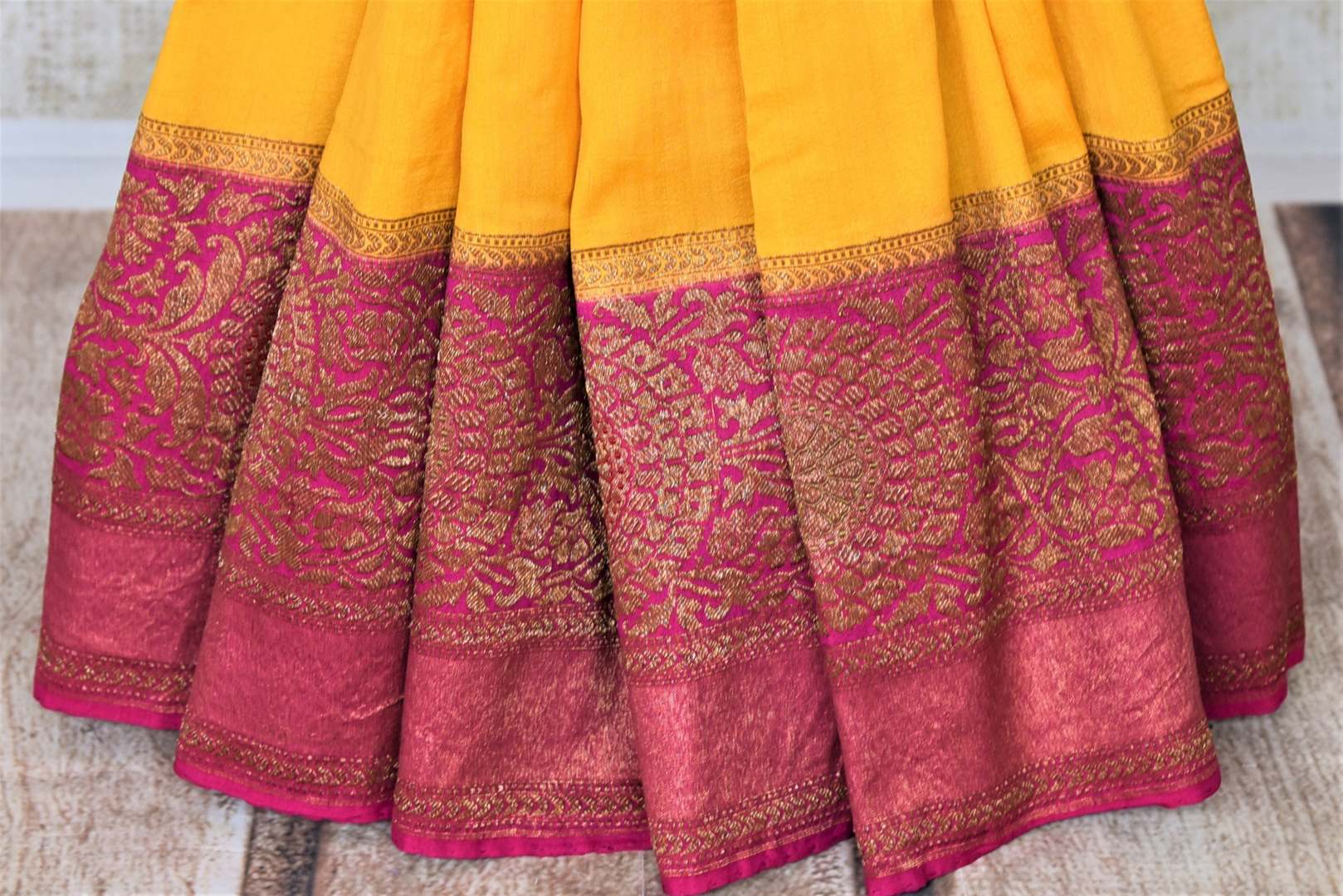 Shop bright yellow tussar Banarsi saree online in USA with pink antique zari border. Be the center of attraction at parties and weddings with beautiful Kanchipuram silk sarees, pure silk sarees, handwoven sarees, Banarasi sarees from Pure Elegance Indian fashion store in USA.-pleats