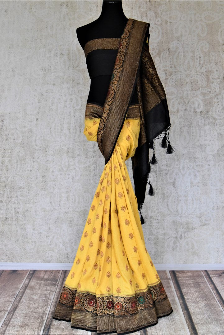 Shop stunning yellow muga Banarasi sari online in USA with black antique zari floral border. Keep your ethnic style updated with latest designer sarees, handloom sarees, pure silk sarees from Pure Elegance Indian fashion store in USA.-full view