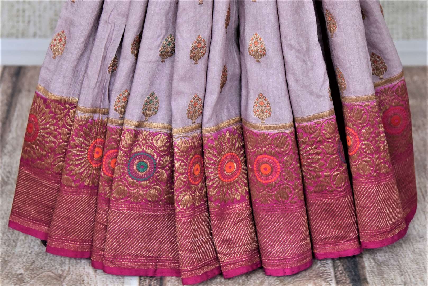 Buy lavender muga Banarasi sari online in USA with pink antique zari floral border. Keep your ethnic style updated with latest designer sarees, handloom sarees, pure silk sarees from Pure Elegance Indian fashion store in USA.-pleats