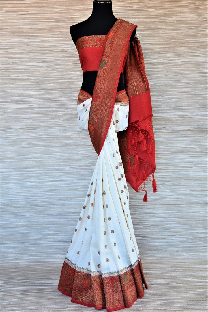 Shop traditional off-white muga Banarasi saree online in USA with antique zari minakari red border and buta. Be a vision of tradition and elegance on weddings and festivals with exquisite Banarasi silk sarees, pure silk sarees, handwoven sarees from Pure Elegance Indian clothing store in USA.-full view