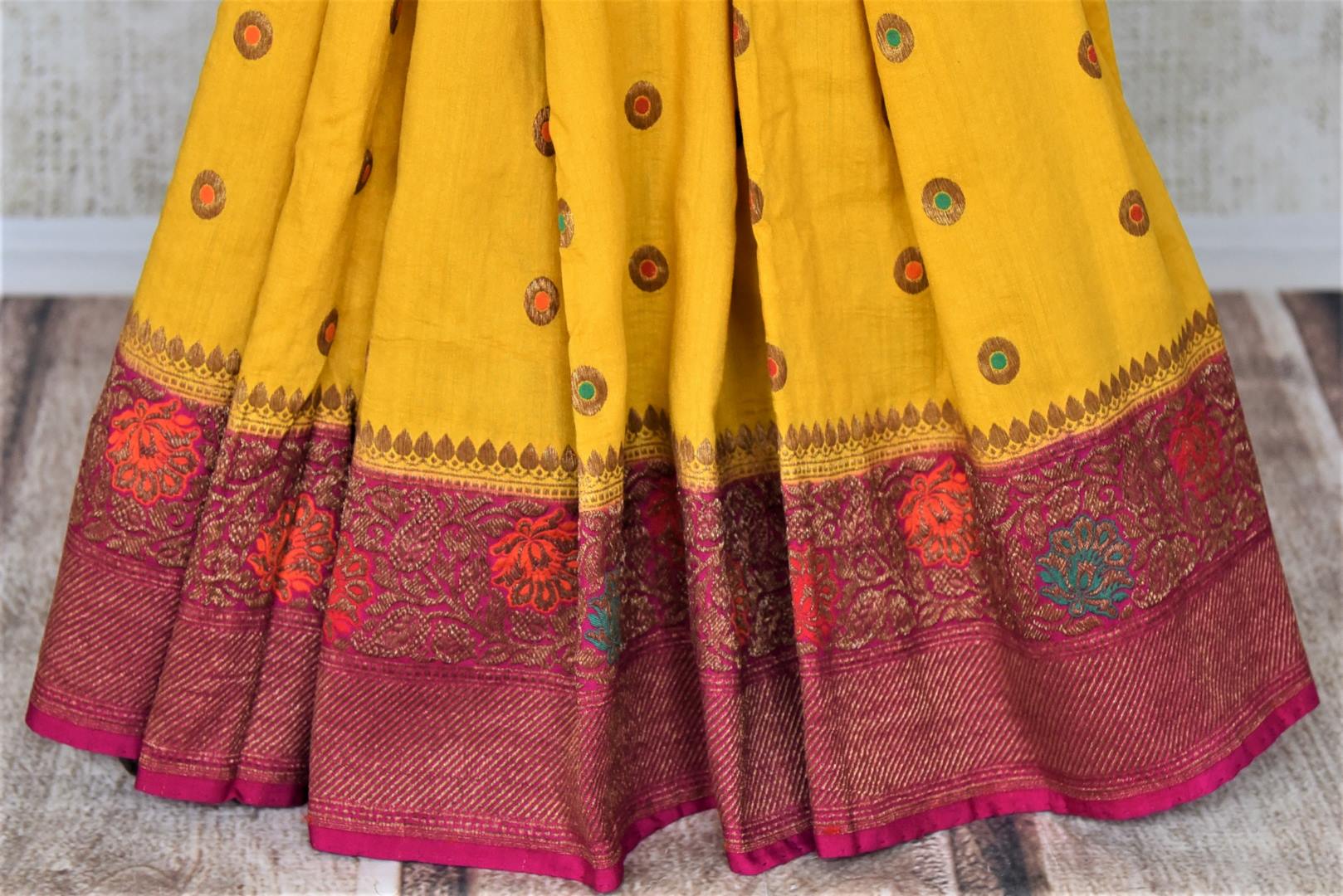 Buy yellow muga Benarasi saree online in USA with pink antique zari floral border. Keep your ethnic style updated with latest designer sarees, handloom sarees, muga silk sarees from Pure Elegance Indian fashion store in USA.-pleats