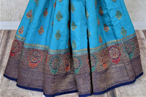 Buy beautiful blue muga Benarasi sari online in USA with dark blue antique zari floral border. Keep your ethnic style updated with latest designer sarees, handloom sarees, muga silk sarees from Pure Elegance Indian fashion store in USA.-pleats