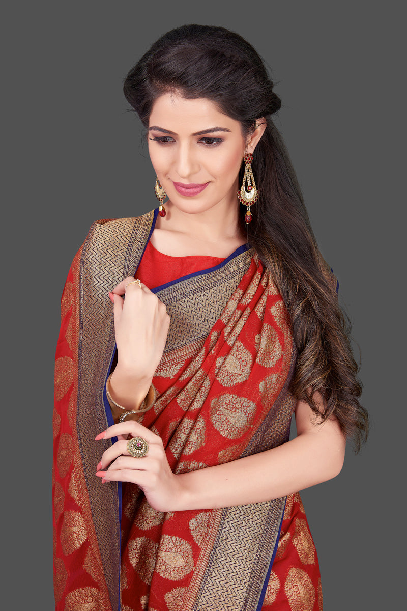 Buy bright red georgette Banarasi sari online in USA with blue zari border. Shop beautiful Banarasi sarees, georgette sarees, pure muga silk sarees in USA from Pure Elegance Indian fashion boutique in USA. Get spoiled for choices with a splendid variety of Indian saris to choose from! Shop now.-closeup