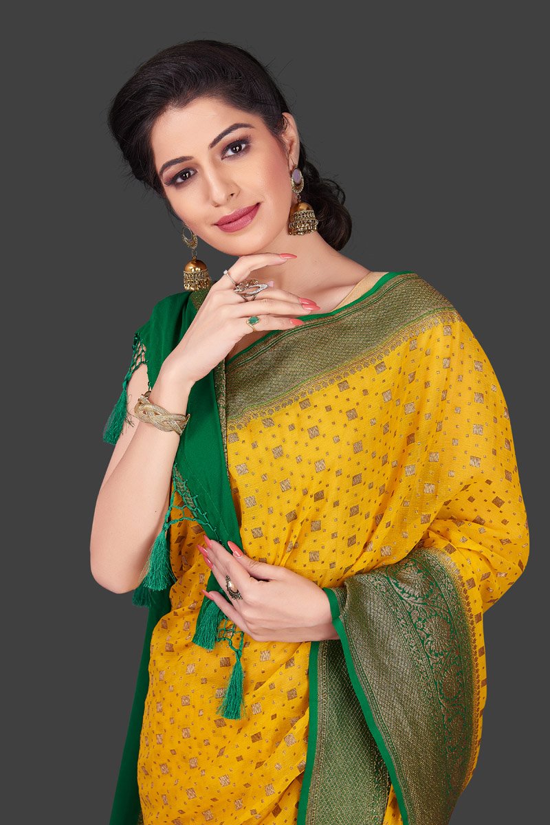 Buy beautiful yellow georgette Benarasi saree online in USA with green zari border. Shop beautiful Banarasi sarees, georgette sarees, pure muga silk sarees in USA from Pure Elegance Indian fashion boutique in USA. Get spoiled for choices with a splendid variety of Indian saris to choose from! Shop now.-closeup