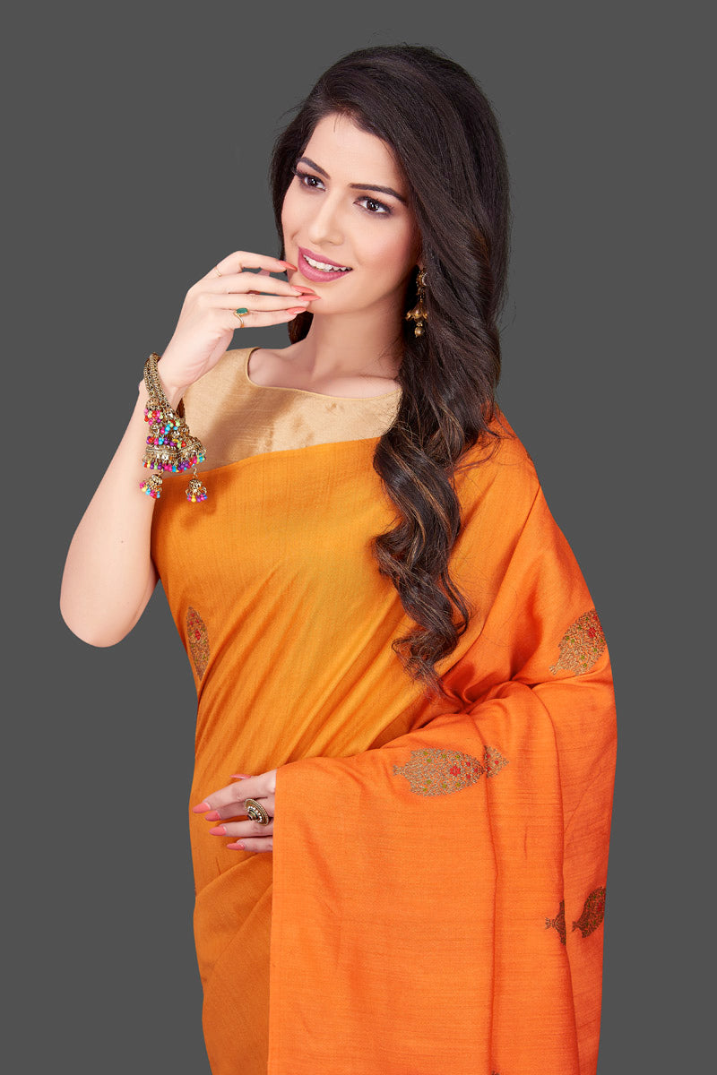 Buy charming orange and yellow borderless muga Benarasi sari online in USA with antique zari buta. Shop beautiful Banarasi sarees, georgette sarees, pure muga silk sarees in USA from Pure Elegance Indian fashion boutique in USA. Get spoiled for choices with a splendid variety of Indian saris to choose from! Shop now.-closeup