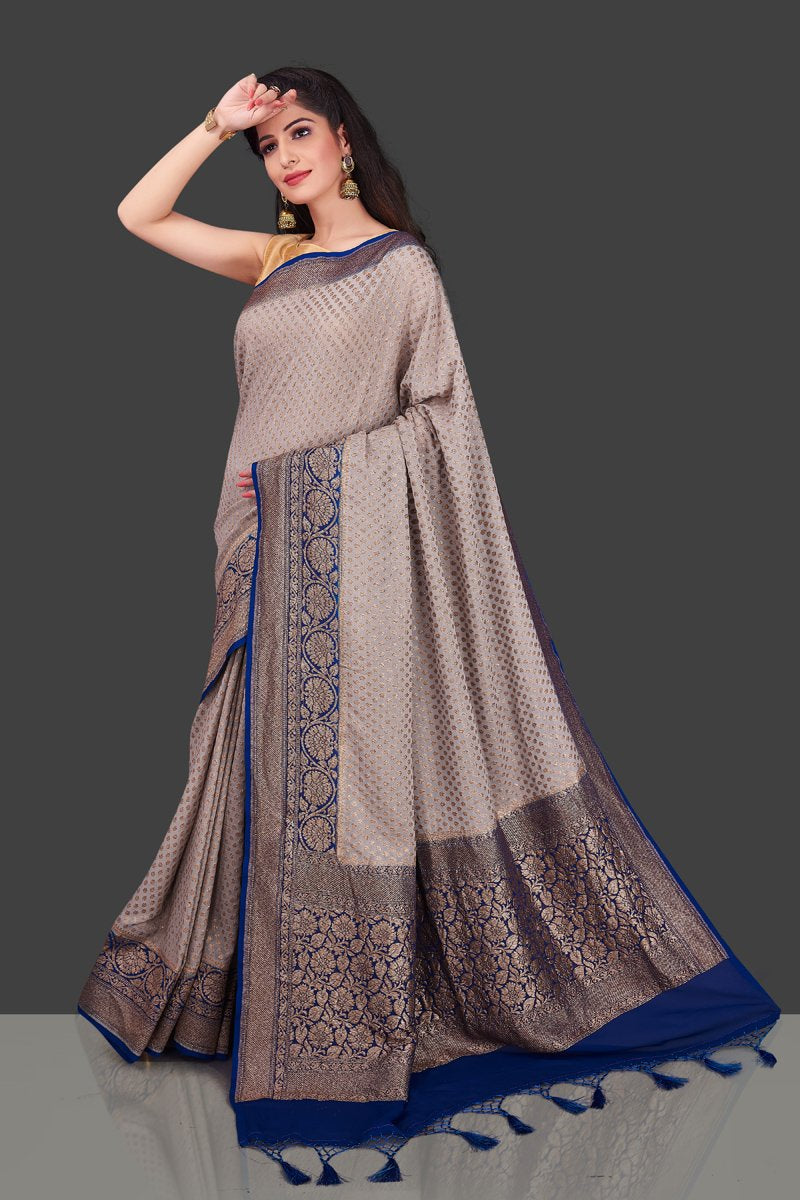 Buy light grey georgette Benarasi sari online in USA with blue zari border. Shop beautiful Banarasi sarees, georgette sarees, pure muga silk sarees in USA from Pure Elegance Indian fashion boutique in USA. Get spoiled for choices with a splendid variety of Indian saris to choose from! Shop now.-front