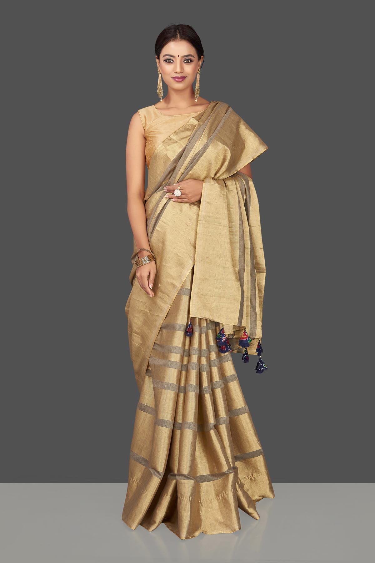 Shop golden tissue tassar saree online in USA with blue tassels on pallu. Keep it elegant with handwoven saris, Tassar silk sarees, tissue sarees from Pure Elegance Indian fashion boutique in USA. We bring a especially curated collection of ethnic sarees for Indian women in USA under one roof!-front