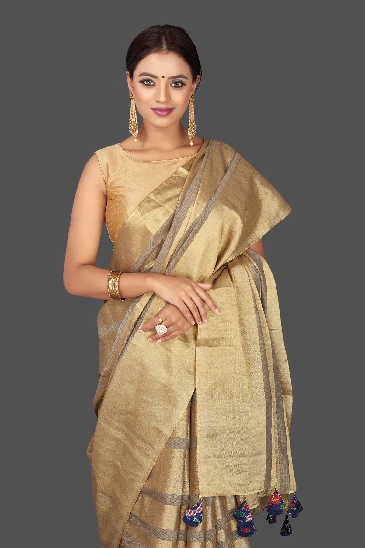 Shop golden tissue tassar saree online in USA with blue tassels on pallu. Keep it elegant with handwoven saris, Tassar silk sarees, tissue sarees from Pure Elegance Indian fashion boutique in USA. We bring a especially curated collection of ethnic sarees for Indian women in USA under one roof!-closeup