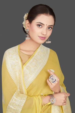 Shop charming yellow color chiffon georgette saree online in USA with silver zari border. Go for stunning Indian designer sarees, georgette sarees, handwoven saris, embroidered sarees for festive occasions and weddings from Pure Elegance Indian clothing store in USA.-closeup