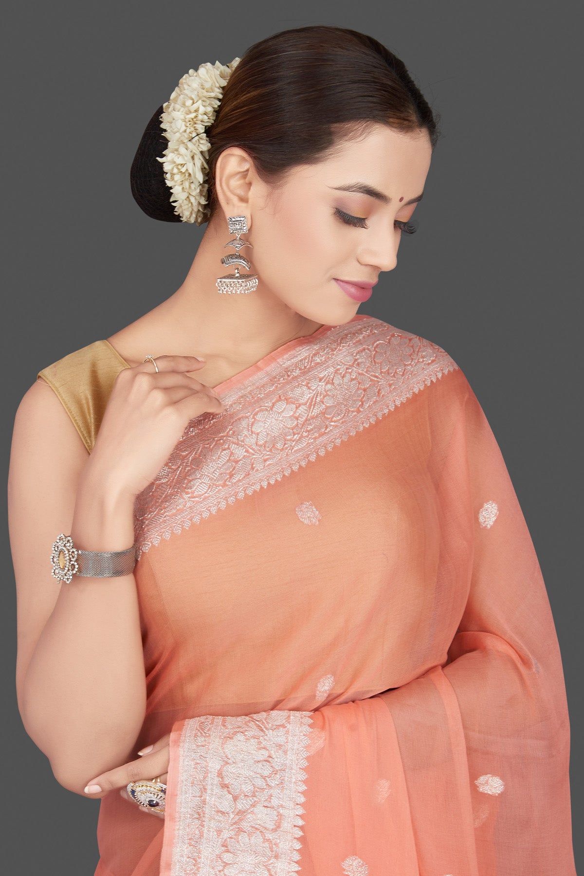 Buy stunning peach color georgette chiffon saree online in USA with silver zari border. Go for stunning Indian designer sarees, georgette sarees, handwoven sarees, embroidered sarees for festive occasions and weddings from Pure Elegance Indian clothing store in USA.-closeup