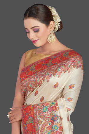 Shop stunning cream tussar muga silk saree online in USA with Kani weave. Make your presence felt on special occasions in beautiful embroidered sarees, handwoven saris, pure silk saris, tussar sarees from Pure Elegance Indian saree store in USA.-closeup