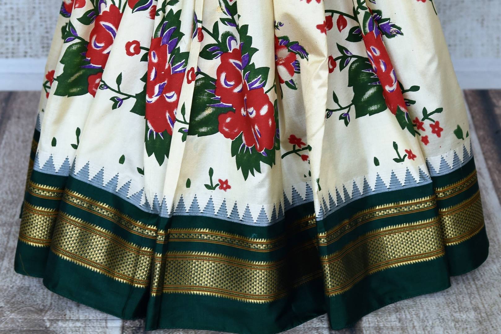 Buy gorgeous cream floral print Gadhwal silk sari online in USA with green zari border. Be the center of attraction at weddings and special occasions in exquisite designer sarees, handwoven silk saris, organza sarees, pure silk saris from Pure Elegance Indian fashion store in USA.-pleats