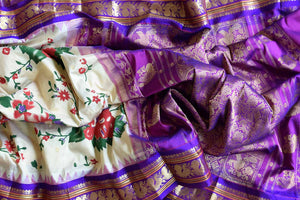 Shop beautiful cream floral print Gadhwal silk saree online in USA with purple zari border. Be the center of attraction at weddings and special occasions in exquisite designer sarees, handwoven silk saris, organza sarees, pure silk saris from Pure Elegance Indian fashion store in USA.-details