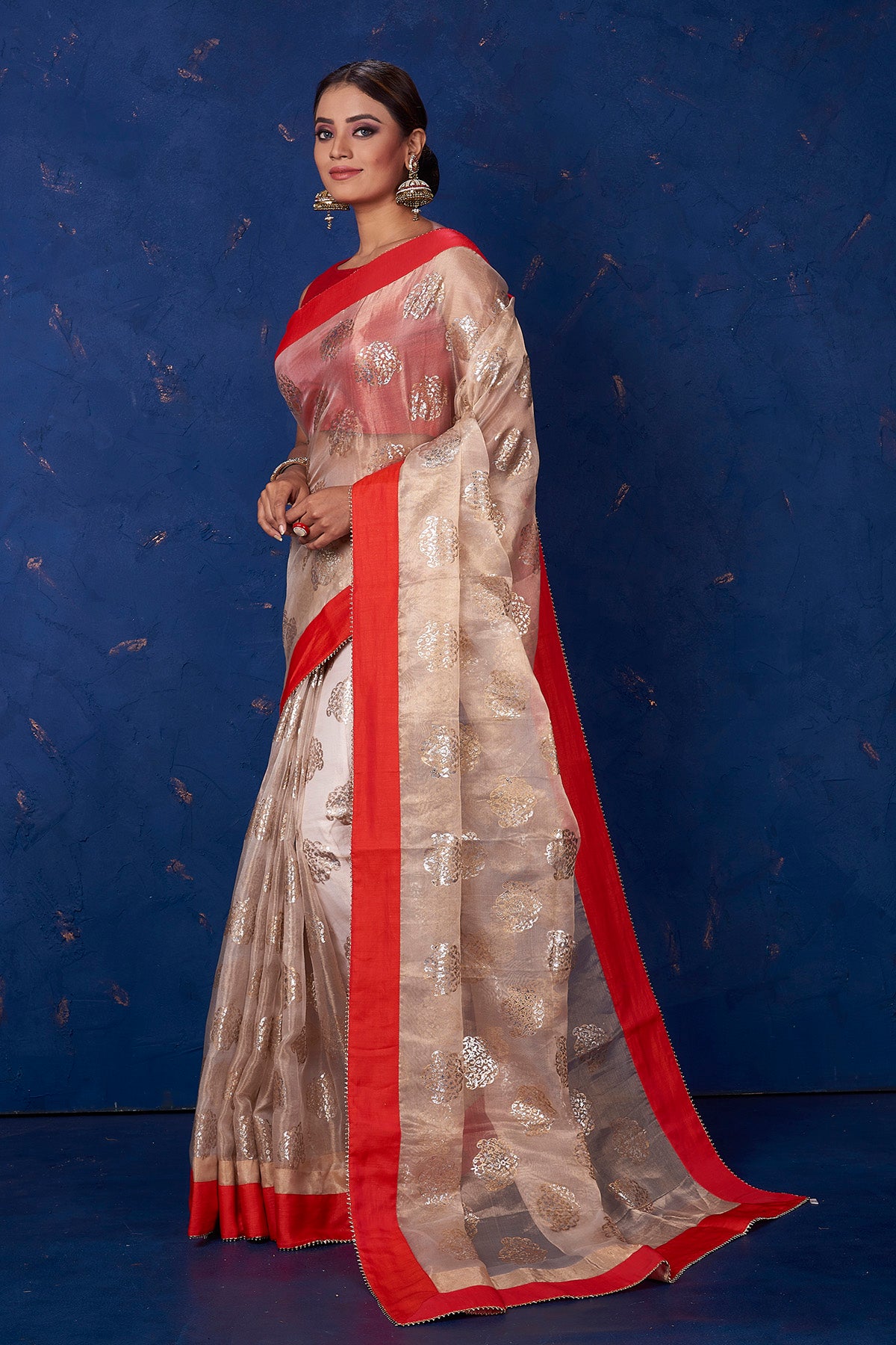 Buy gorgeous beige foil print organza saree online in USA with solid red border. Keep your ethnic wardrobe with exclusive designer sarees, handloom sarees, pure silk sarees, soft silk sarees, Banarasi silk sarees from Pure Elegance Indian fashion store in USA.-pallu