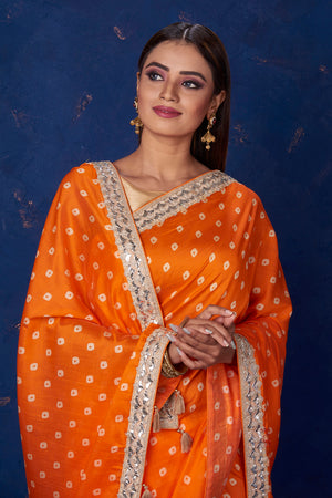 Buy beautiful orange bandhej chanderi saree online in USA with embroidered border. Keep your ethnic wardrobe up to date with latest designer sarees, pure silk sarees, handwoven sarees, tussar silk sarees, embroidered sarees from Pure Elegance Indian saree store in USA.-closeup