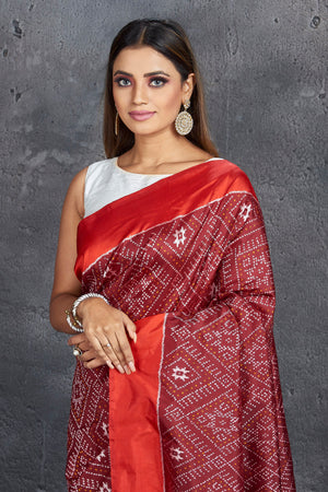 Buy stunning maroon ikkat silk saree online in USA with red border and pallu. Keep your ethnic wardrobe up to date with latest designer sarees, pure silk sarees, handwoven sarees, tussar silk sarees, embroidered saris, Paithani sarees from Pure Elegance Indian saree store in USA.-closeup