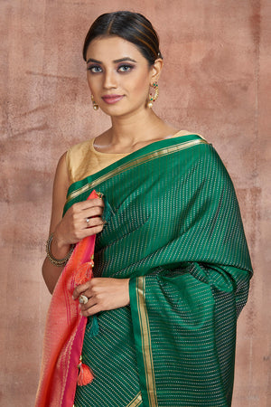 Shop stunning dark green Kanjivaram silk saree online in USA with pink zari pallu. Keep your ethnic wardrobe up to date with latest designer sarees, pure silk sarees, handwoven sarees, tussar silk sarees, embroidered sarees from Pure Elegance Indian saree store in USA.-closeup