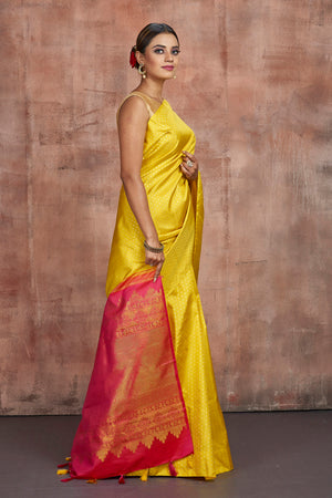Shop beautiful yellow Kanjivaram silk sari online in USA with pink zari pallu. Keep your ethnic wardrobe up to date with latest designer sarees, pure silk sarees, handwoven sarees, tussar silk saris, embroidered sarees from Pure Elegance Indian saree store in USA.-side