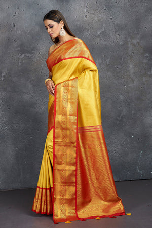 Shop stunning yellow Kanjeevaram silk saree online in USA with red zari border. Keep your ethnic wardrobe up to date with latest designer sarees, pure silk sarees, Kanchipuram silk sarees, handwoven sarees, tussar silk sarees, embroidered sarees from Pure Elegance Indian saree store in USA.-side