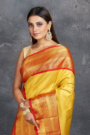 Shop stunning yellow Kanjeevaram silk saree online in USA with red zari border. Keep your ethnic wardrobe up to date with latest designer sarees, pure silk sarees, Kanchipuram silk sarees, handwoven sarees, tussar silk sarees, embroidered sarees from Pure Elegance Indian saree store in USA.-closeup