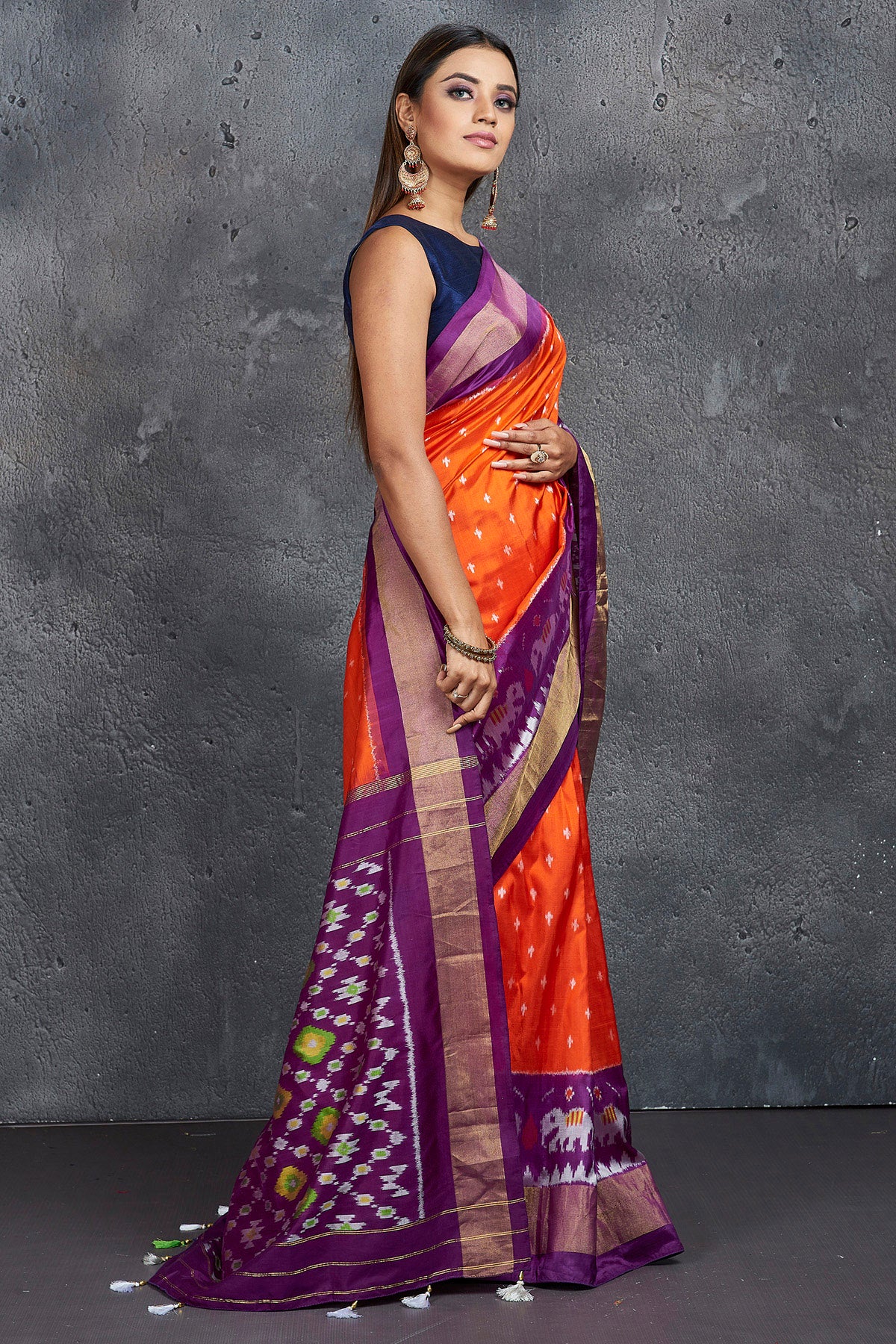 Shop beautiful orange ikkat silk saree online in USA with purple zari border. Keep your ethnic wardrobe up to date with latest designer sarees, pure silk sarees, Kanchipuram silk sarees, handwoven sarees, tussar silk sarees, embroidered sarees from Pure Elegance Indian saree store in USA.-side
