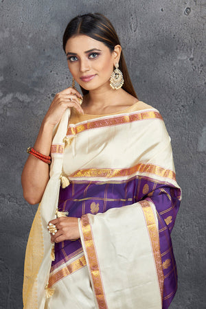 Buy stunning purple check Kanjivaram saree online in USA with cream space border. Keep your ethnic wardrobe up to date with latest designer sarees, pure silk sarees, Kanchipuram silk sarees, handwoven sarees, tussar silk sarees, embroidered sarees from Pure Elegance Indian saree store in USA.-closeup