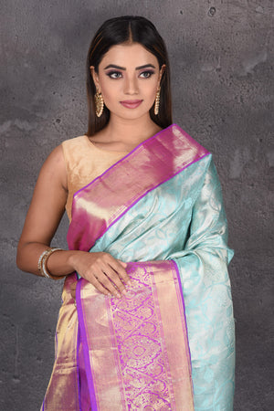 Buy stunning light blue Kanjeevaram sari online in USA with purple zari border. Keep your ethnic wardrobe up to date with latest designer sarees, pure silk sarees, handwoven sarees, tussar silk sarees, embroidered sarees, printed sarees from Pure Elegance Indian saree store in USA.-closeup