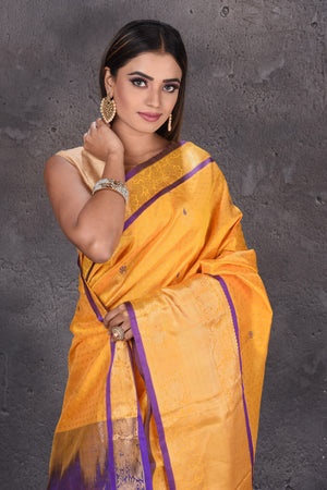 Shop yellow mangalgiri saree online in USA with purple zari pallu. Keep your ethnic wardrobe up to date with latest designer sarees, pure silk sarees, handwoven sarees, tussar silk sarees, embroidered sarees, printed sarees from Pure Elegance Indian saree store in USA.-closeup