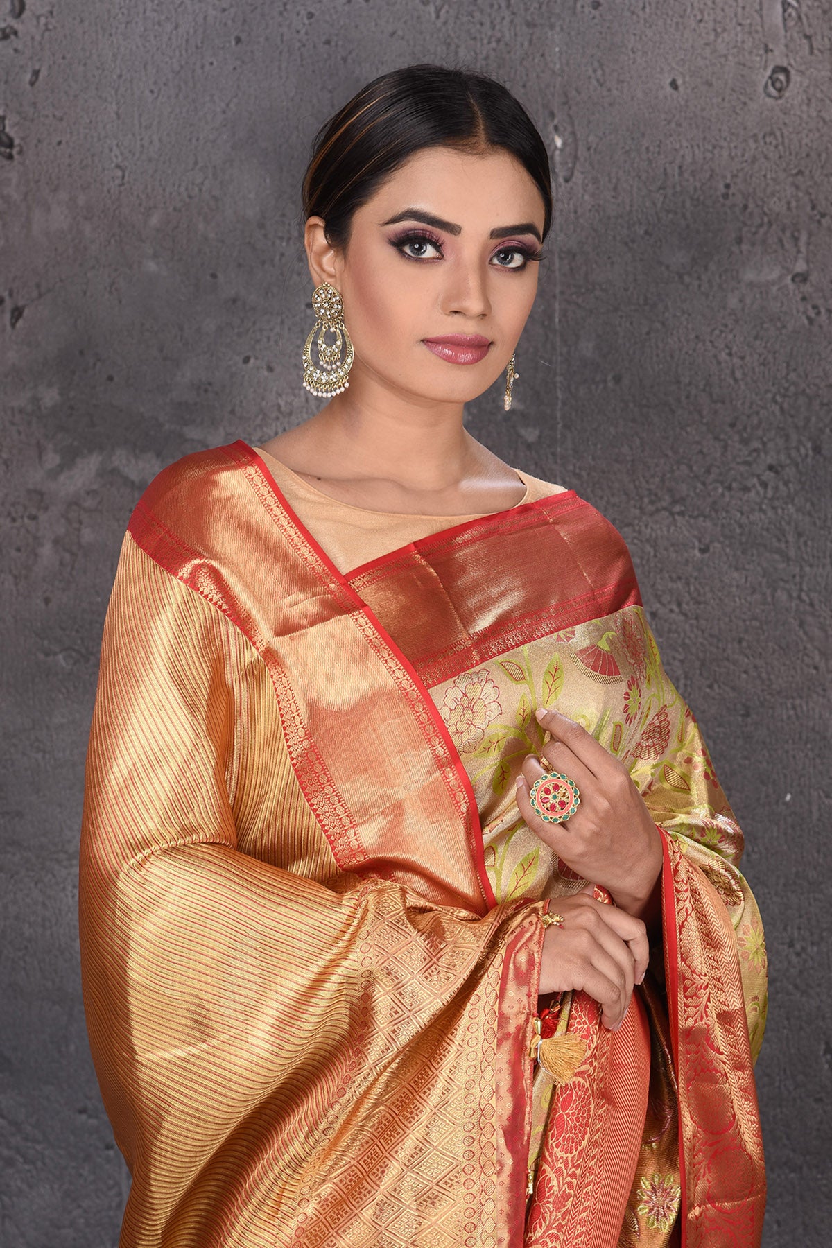 Buy stunning creamish gold floral minakari Kanjeevaram saree online in USA with red golden border. Keep your ethnic wardrobe up to date with latest designer sarees, pure silk sarees, handwoven sarees, Kanchipuram silk sarees, embroidered sarees, georgette sarees from Pure Elegance Indian saree store in USA.-closeup