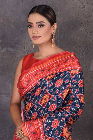 Shop beautiful blue Patola print crepe silk saree online in USA with red border. Flaunt your ethnic style on special occasions with latest designer sarees, pure silk sarees, handwoven sarees, Kanchipuram silk sarees, embroidered sarees, georgette sarees, party sarees from Pure Elegance Indian saree store in USA.-closeup