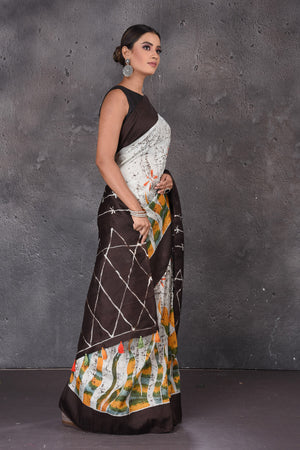 Buy beautiful light grey Batik print silk sari online in USA with brown border and pallu. Flaunt your ethnic style on special occasions with latest designer sarees, pure silk sarees, handwoven sarees, Kanchipuram silk sarees, embroidered sarees, georgette sarees, party sarees from Pure Elegance Indian saree store in USA.-side