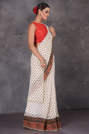 Shop stunning off-white printed georgette sari online in USA with embroidered border. Flaunt your ethnic style on special occasions with latest designer sarees, pure silk sarees, handwoven sarees, Kanchipuram silk sarees, embroidered sarees, georgette sarees, party sarees from Pure Elegance Indian saree store in USA.-side
