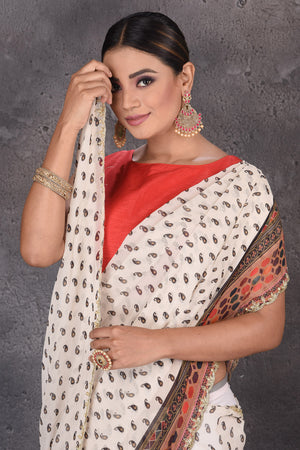 Shop stunning off-white printed georgette sari online in USA with embroidered border. Flaunt your ethnic style on special occasions with latest designer sarees, pure silk sarees, handwoven sarees, Kanchipuram silk sarees, embroidered sarees, georgette sarees, party sarees from Pure Elegance Indian saree store in USA.-closeup