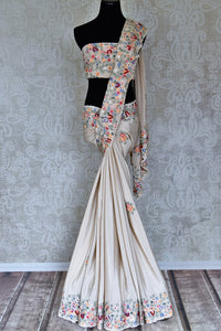Buy beautiful beige floral crepe silk sari online in USA with hand embroidered border. Flaunt your sartorial choices on special occasions in stunning designer sarees, embroidered sarees, handloom sarees, Banarasi sarees, crepe sarees from Pure Elegance Indian fashion store in USA.-full view