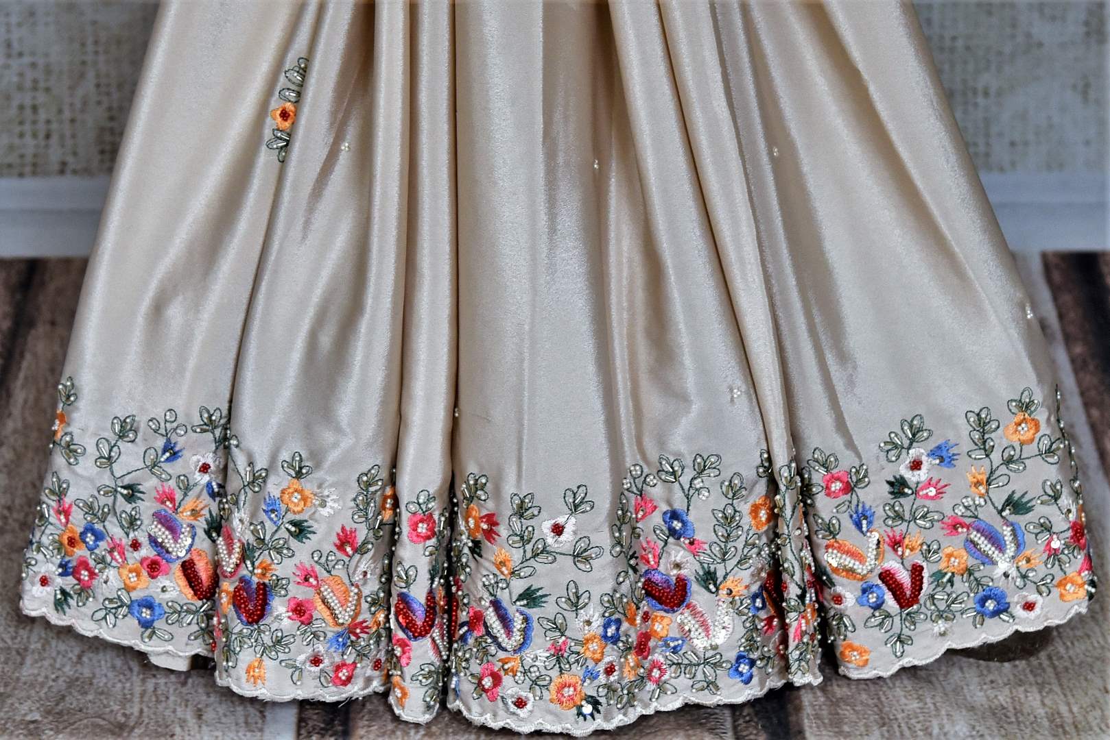 Buy beautiful beige floral crepe silk sari online in USA with hand embroidered border. Flaunt your sartorial choices on special occasions in stunning designer sarees, embroidered sarees, handloom sarees, Banarasi sarees, crepe sarees from Pure Elegance Indian fashion store in USA.-pleats