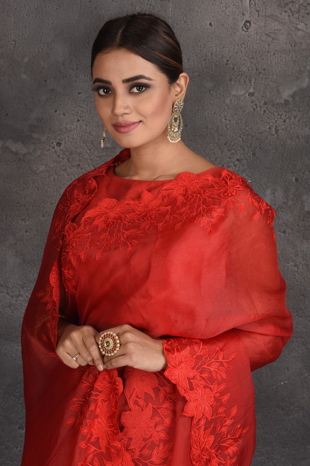 Shop beautiful red organza saree online in USA with floral cut-work border. Keep your ethnic wardrobe up to date with latest designer sarees, pure silk sarees, handwoven sarees, tussar silk sarees, embroidered sarees, organza saris from Pure Elegance Indian fashion store in USA.-closeup