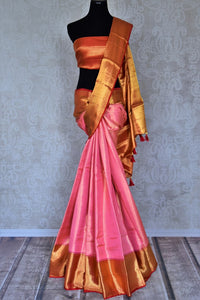 Buy stunning light pink Kanjivaram silk saree online in USA with red zari border. Flaunt your sartorial choices on special occasions in stunning designer sarees, embroidered sarees, handloom sarees, Banarasi sarees, crepe sarees from Pure Elegance Indian fashion store in USA.-full view