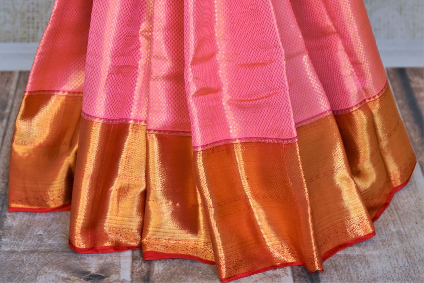 Buy stunning light pink Kanjivaram silk saree online in USA with red zari border. Flaunt your sartorial choices on special occasions in stunning designer sarees, embroidered sarees, handloom sarees, Banarasi sarees, crepe sarees from Pure Elegance Indian fashion store in USA.-pleats