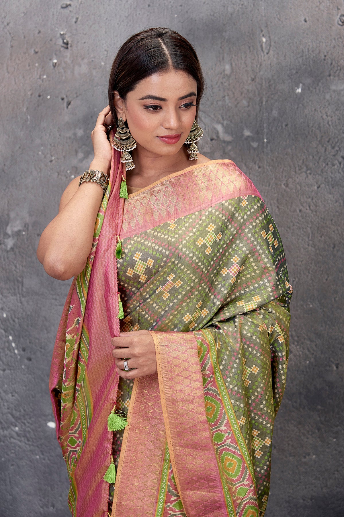 Buy stunning sage green fancy Patola saree online in USA with pink zari border. Keep your ethnic wardrobe up to date with latest designer saris, pure silk sarees, handwoven sarees, tussar silk sarees, embroidered saris from Pure Elegance Indian saree store in USA.-closeup