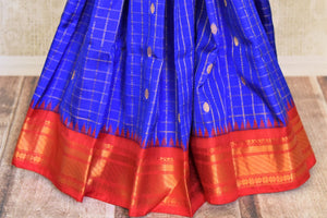 Buy beautiful royal blue Gadhwal silk saree online in USA with red zari border. Look elegant on special occasions in beautiful printed sarees, silk sarees, tussar sarees, handloom sarees, Kanchipuram sarees from Pure Elegance Indian saree store in USA.-pleats