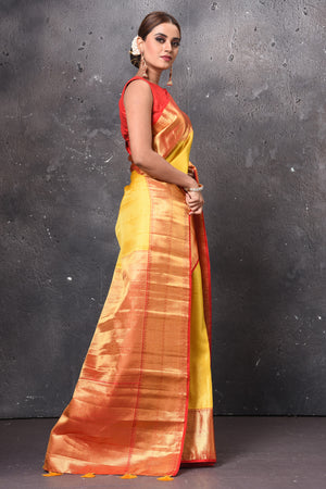 Shop beautiful yellow handloom Kanjivaram sari online in USA with red zari border. Keep your ethnic wardrobe up to date with latest designer sarees, pure silk sarees, handwoven sarees, tussar silk sarees, embroidered sarees, chiffon saris from Pure Elegance Indian saree store in USA.-side