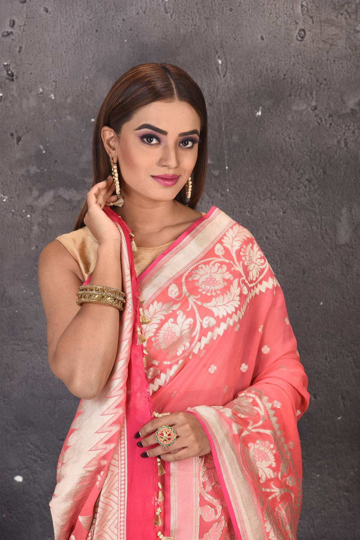 Buy beautiful salmon pink fancy georgette saree online in USA with zari work. Keep your ethnic wardrobe updated with latest designer sarees, pure silk sarees, handwoven sarees, tussar silk sarees, embroidered sarees from Pure Elegance Indian saree store in USA.-closeup