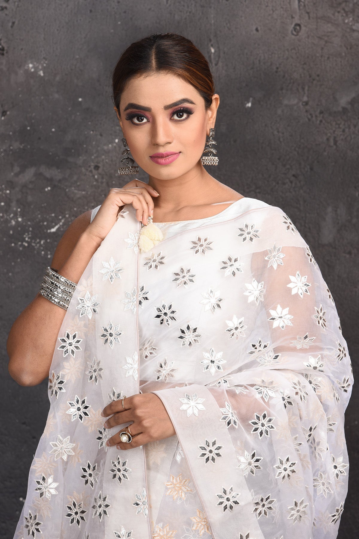 Buy beautiful white organza saree online in USA with silver applique work. Keep your ethnic wardrobe up to date with latest designer sarees, pure silk sarees, handwoven sarees, tussar silk sarees, embroidered sarees from Pure Elegance Indian saree store in USA.-closeup