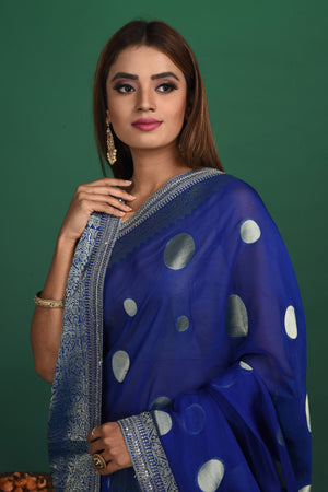 Buy beautiful royal blue georgette Banarasi sari online in USA with silver zari border. Keep your ethnic wardrobe up to date with latest designer sarees, pure silk sarees, handwoven sarees, tussar silk sarees, embroidered sarees, organza saris from Pure Elegance Indian saree store in USA.-closeup
