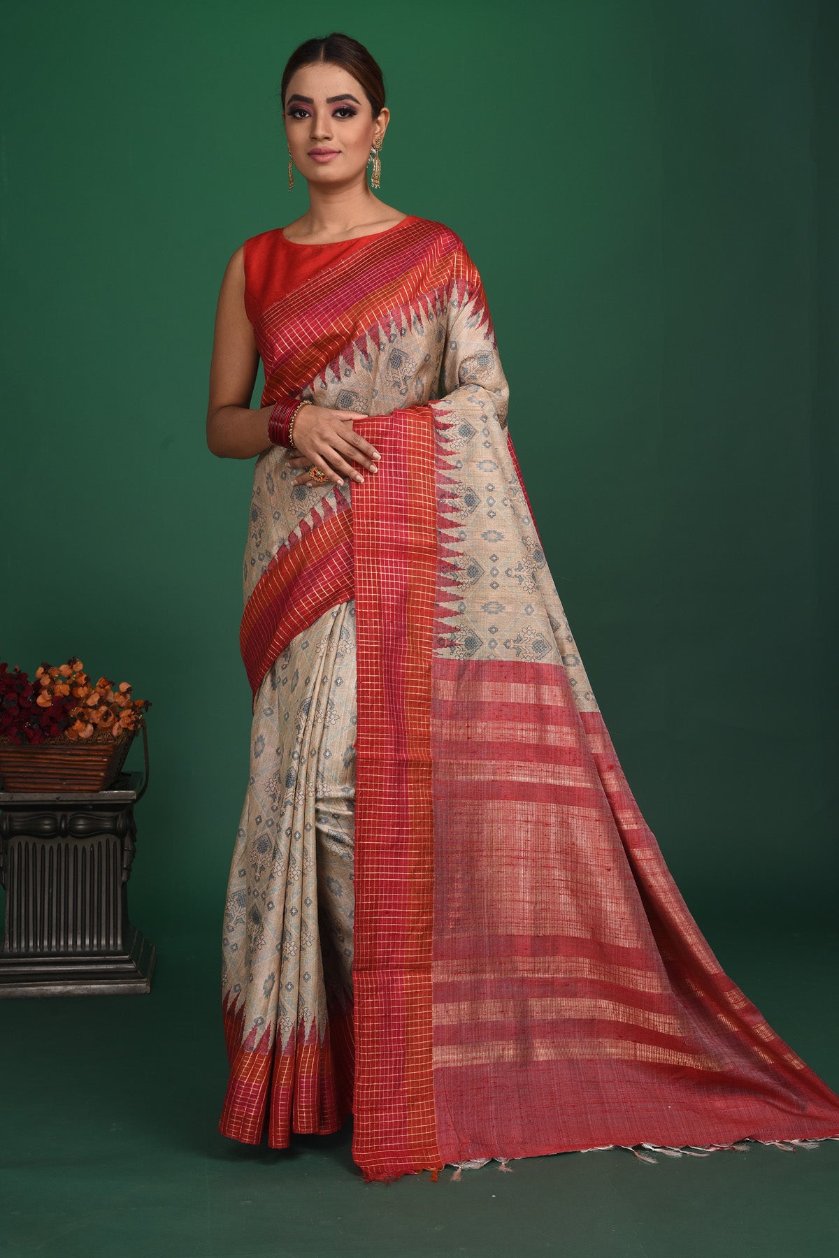 Shop this exquisite beige tussar saree with red vidharbha and zari border online in USA which is handcrafted from fine silk tussar fabric, this tie and dye saree brings out the nature of flow. This tussar saree with elegant red Vidharbha border is making everyone swoon over it. Make it yours and flaunt a handwoven marvel with minimal jewellery for a casual day outfit. Add this pure tussar saree to your collection from Pure Elegance Indian fashion store in USA.-Full view with open pallu.
